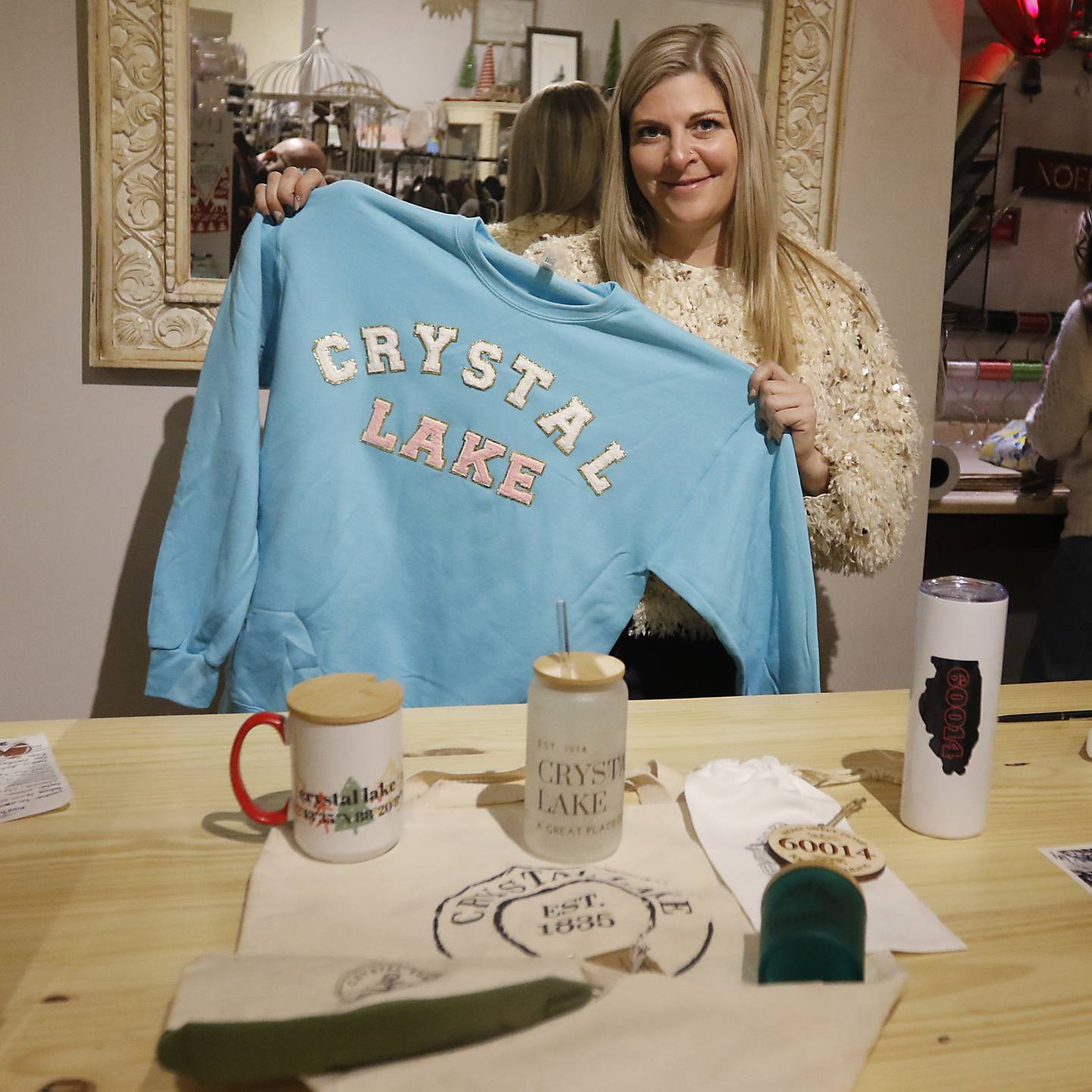 Nicole Garringer of Out of the Box shows off Crystal Lake branded sweatshirt on Friday, Dec. 1, 2023, in Downtown Crystal Lake.