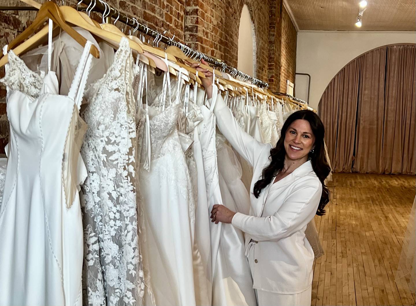 Manager Kelle Bliss looks through the wedding dress selection at Savy's Chic Bridal Boutique's new location at 313 First Ave. in Sterling.