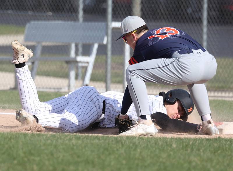 DeKalb's Paul Kakoliris dives back to first safely as Naperville North’s Lawton Close applies the tag Tuesday, April 15, 2025, during their game at DeKalb High School.