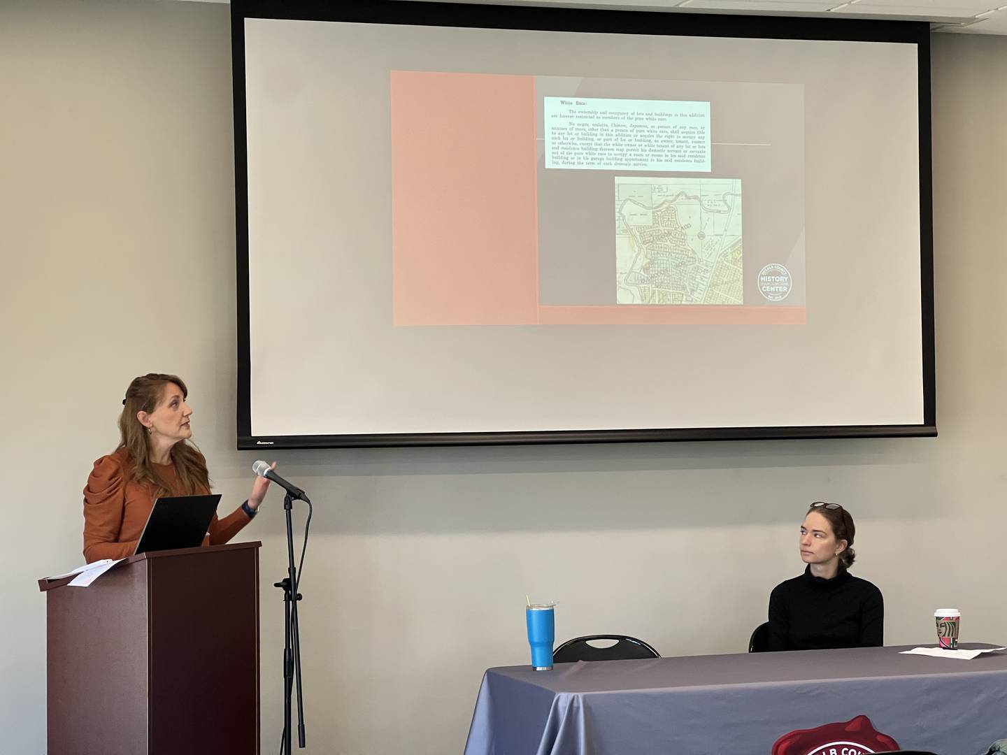 On the right, Audrey King, from the Ellwood House Museum listens as DeKalb County Historian and Executive Director of DeKalb County History Center, Michele Donahoe tells a small audience about the history of racially segregated housing in DeKalb County during an Arts in Action event on Feb. 1, 2024.