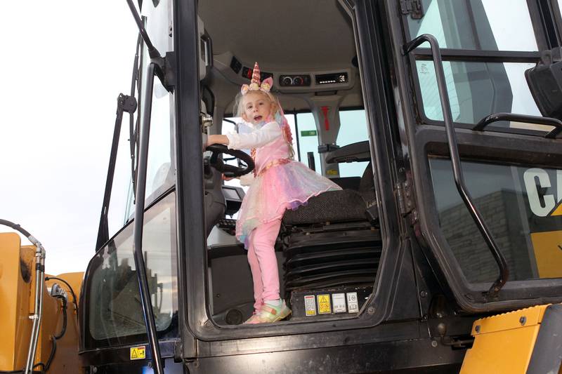 Sylvia Bussan, 6, of Ingleside, dressed in her costume, checks out a Village of Fox Lake Public Works front end loader on display during the Halloween Howl at the Village of Fox Lake Police Department.