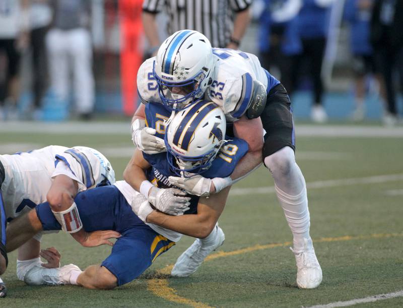 Wheaton North’s Matt Kuczaj is tackled by St. Charles North’s Jake Furtney (right) during a game in Wheaton on Friday, Sept. 8, 2023.