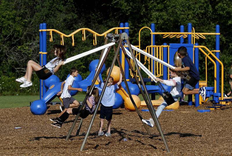 Children swing and play on the playground before the start of the first day of school at West Elementary School in Crystal Lake on Wednesday, Aug. 16, 2023.