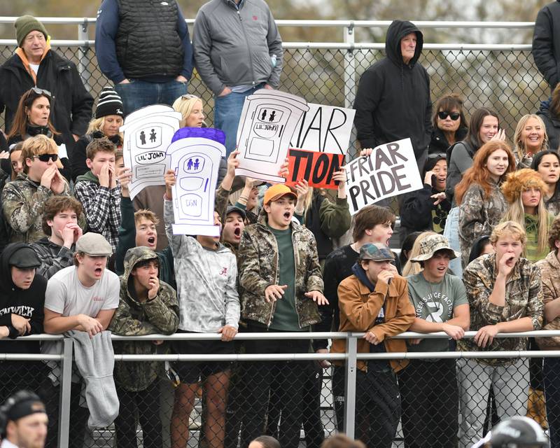 Fenwick fans hold up signs while playing defense on Saturday Nov. 9, 2024, during the second week of class 7A game while traveling to take on Downers Grove North High School.