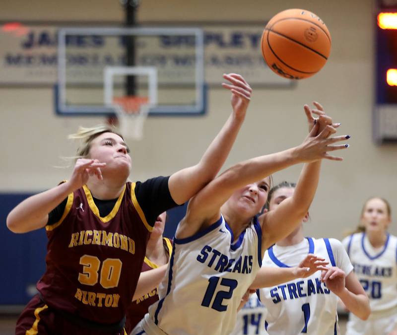 Richmond-Burton's Chase Cooper battles with Woodstock's Hayden Williams for a rebound during a Kishwaukee River Conference girls basketball game on Wednesday, Jan. 28, 2026, at Woodstock High School.