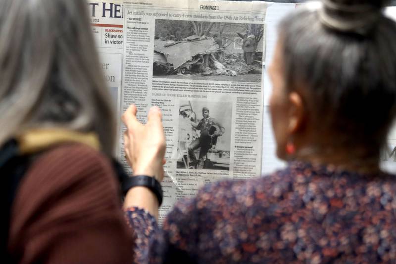 People view news clippings as a remembrance was held Saturday at Wonder Lake Fire Protection District Station 2 on the 40th anniversary of a midair military jet explosion that happened over the small, rural area northeast of Woodstock. The plane exploded midair at 9:11 p.m., and its flaming pieces rained over a 2-mile area near Greenwood. On board were more than two-dozen members of the Air Force Reserve and Air National Guard. Twenty-seven people died.