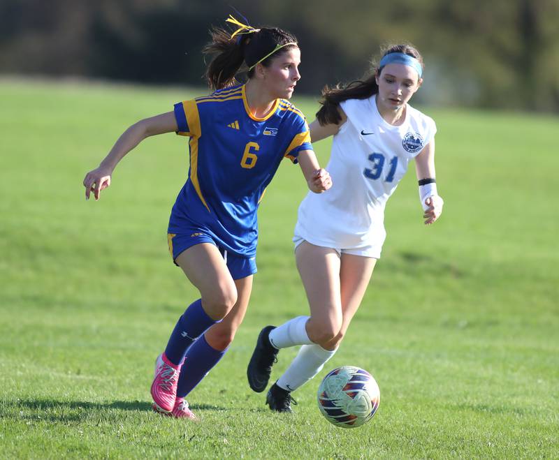 Johnsburg’s Liz Smith, left, moves past Woodstock’s Alyssa Fetzer in varsity soccer on Wednesday, April 23, 2025, at Johnsburg High School in Johnsburg.