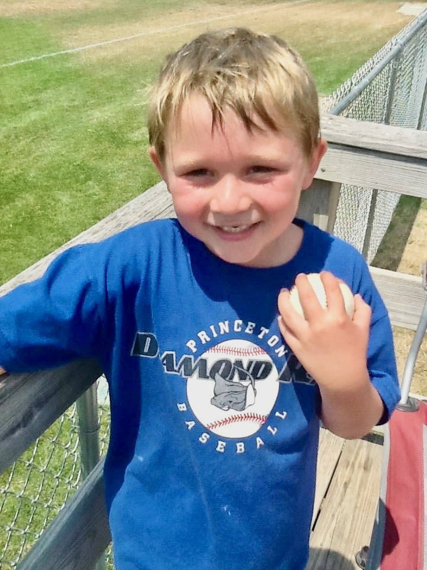 Jordan Reinhardt, 5, clutches the baseball given to him by his brother's travel team. The ball helped spark his recovery from a near tragic Easter Sunday four-wheeler accident in 2012.
