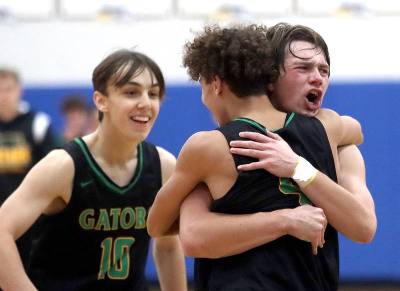 Crystal Lake South’s Cam Miller, left, joins the celebration while AJ Demirov, front, is embraced by Cooper LePage as the Gators won against Huntley in the title game of the Johnsburg Thanksgiving tournament in boys basketball on Friday.