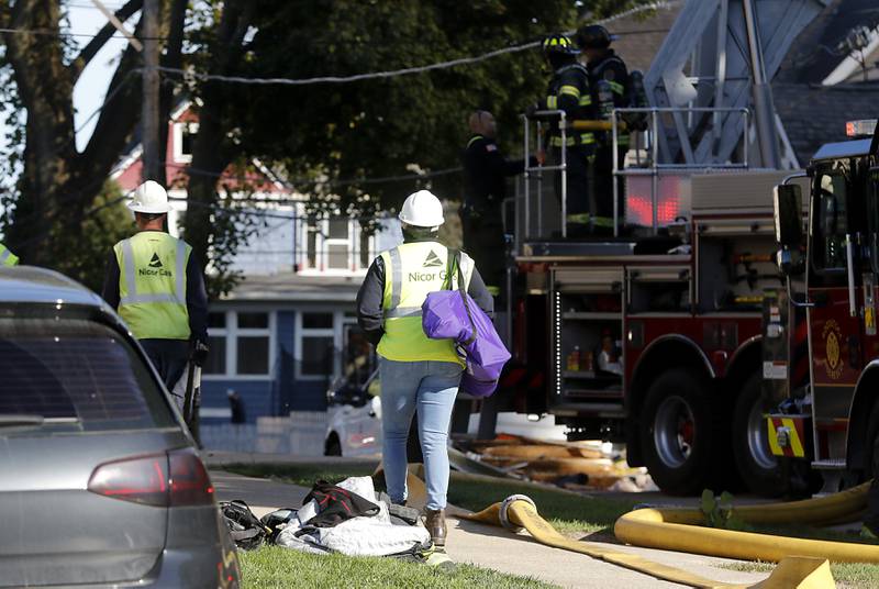 Nicor Gas workers at the scene a house fire in the 300 block of Lincoln Avenue in Woodstock Monday, Oct. 9, 2023, after an explosion following suspected gas leak in the area.