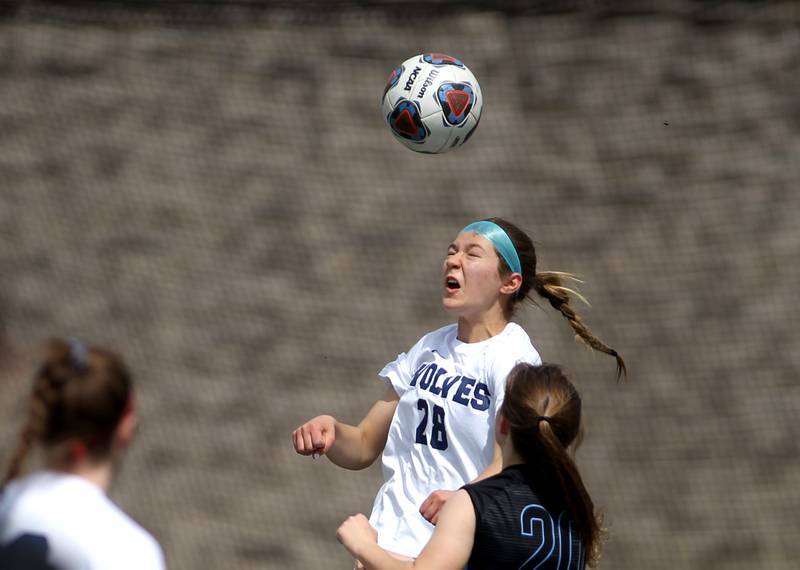 Oswego East’s Abigail Triska (28) heads the ball during a Naperville Invitational game against St. Charles North at Naperville Central on Saturday, April 23, 2022.
