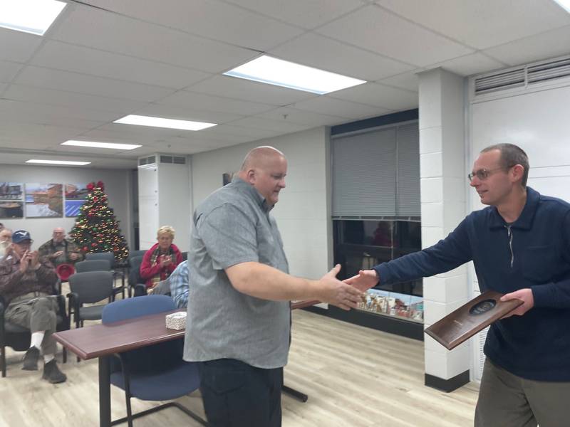 Utica police officer Mark Credi (left) accepts a plaque from Mayor David Stewart Thursday, Dec. 19, 2024, at the meeting of the Utica Village Board. Credi, a longtime Peru police officer, retired from Utica after nearly eight years' service.