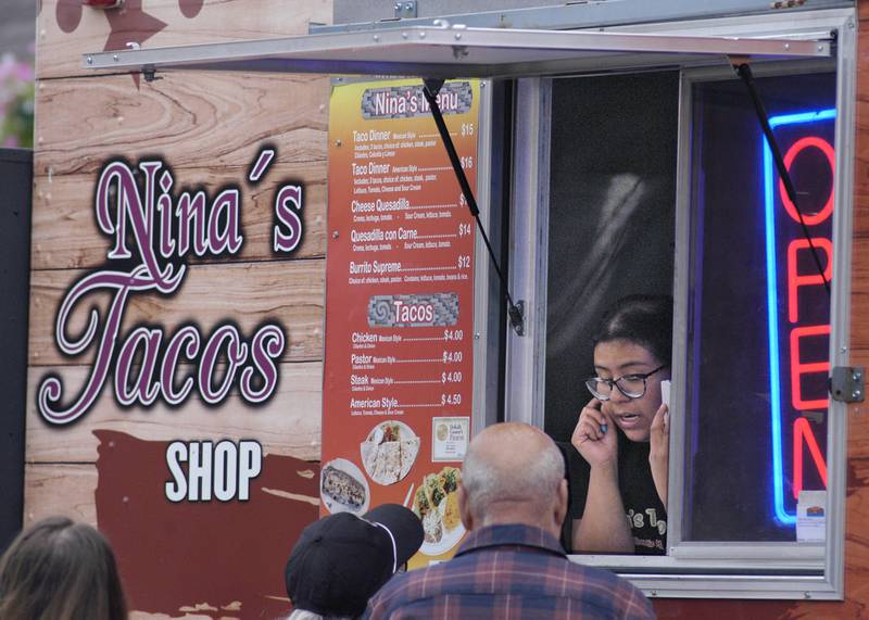 Leslie Munoz of Nina's Tacos in Sycamore listens to a customer's order at River Country 101.7's Summer Kickoff. The event was held om the Dixon Riverfront June 1, 2024.