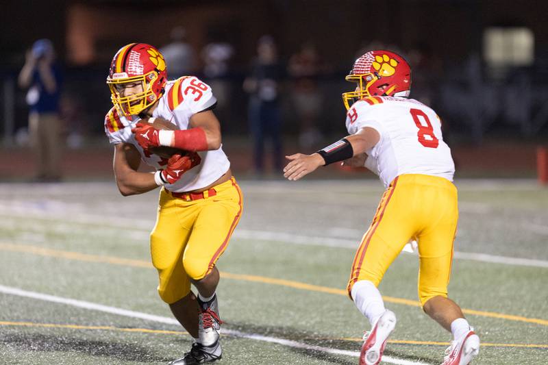Batavia's Michael Vander Luitgaren  hands the ball off to Preston Brummel against St. Charles North on Friday, Sept. 26, 2025 in St. Charles.