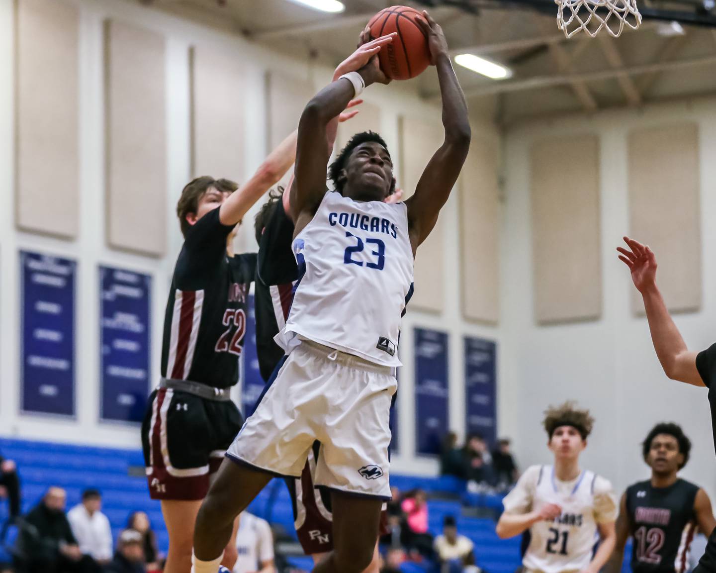 Plainfield South's Jeremiah Lesure (23) is fouled at the rim by Plainfield North's Evan Czarnik (22) during basketball game between Plainfield North at Plainfield South. Jan 5, 2024.
