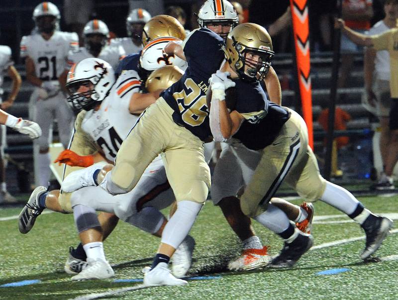 Lemont running back Albert Kunickis (26) breaks through the St. Charles East defensive line and goes on to score the first touchdown during a varsity football game at Lemont High School on Friday.