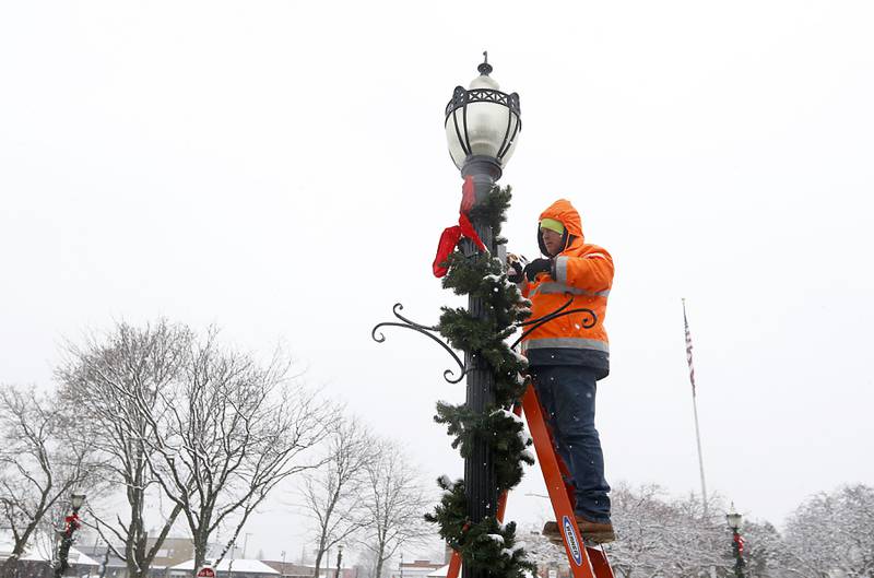 Bill Martenson, from the Crystal Lake Public Works Department, fixes a street light in the snow on Tuesday, Nov. 15, 2022. The McHenry County area received its first measurable snowfall of the season.