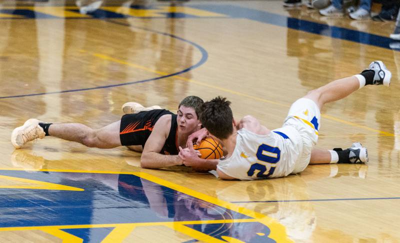 Wheaton Warrenville South’s Zach Rogers, left, and Wheaton North’s Will Channing dive for a ball during a game at Wheaton North High School on Friday, Dec. 20, 2024.