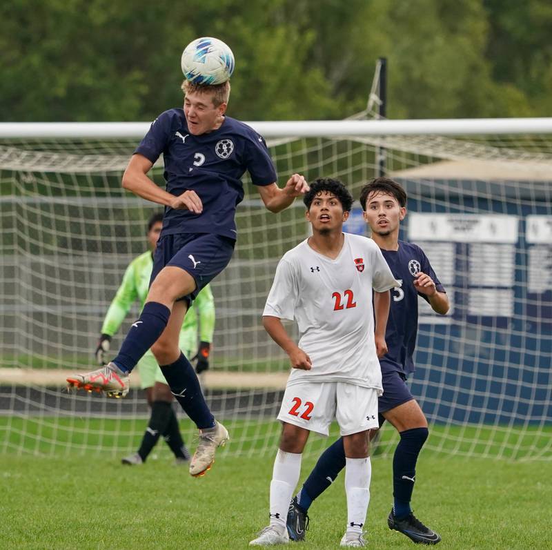 Oswego East's Landon Kangas (3) heads the ball against Oswego during a soccer match at Oswego East High School on Tuesday, Sept. 26, 2023.