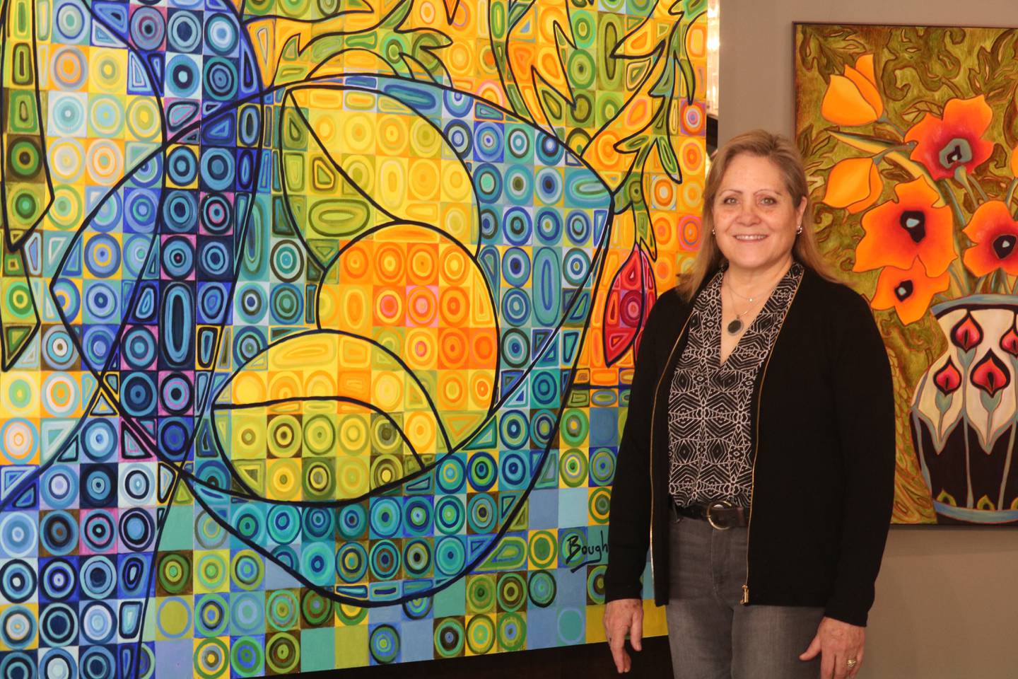 Artifex Studio owner Elisa Boughner is all smiles on Monday, Jan. 26, 2026, standing next to one of the pieces in her art gallery in DeKalb.