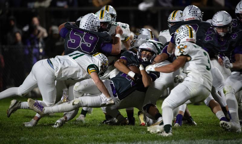 Wilmington's Hunter Kaitschuk, center, carries the ball on a play as Coal City's Mason Garner, left, makes the tackle in a game on Friday, October 24, 2025.