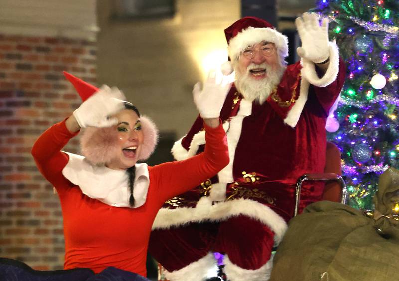 Santa Claus and Elfie wave at attendees as they ride down Lincoln Highway Thursday, Dec. 5, 2024, during the DeKalb Chamber of Commerce’s Lights on Lincoln and Santa Comes to Town in DeKalb.