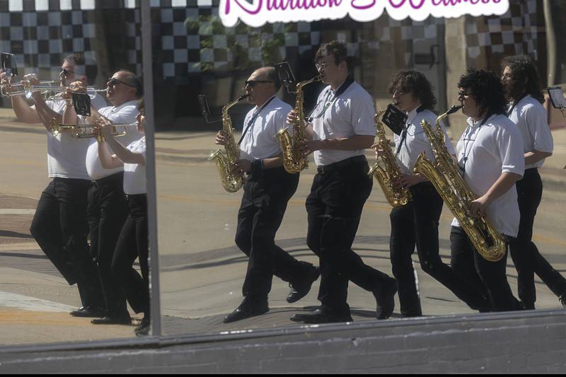 The Dixon Municipal Band is reflected in a downtown business during a Memorial Day parade Monday, May 27, 2024 in Dixon.