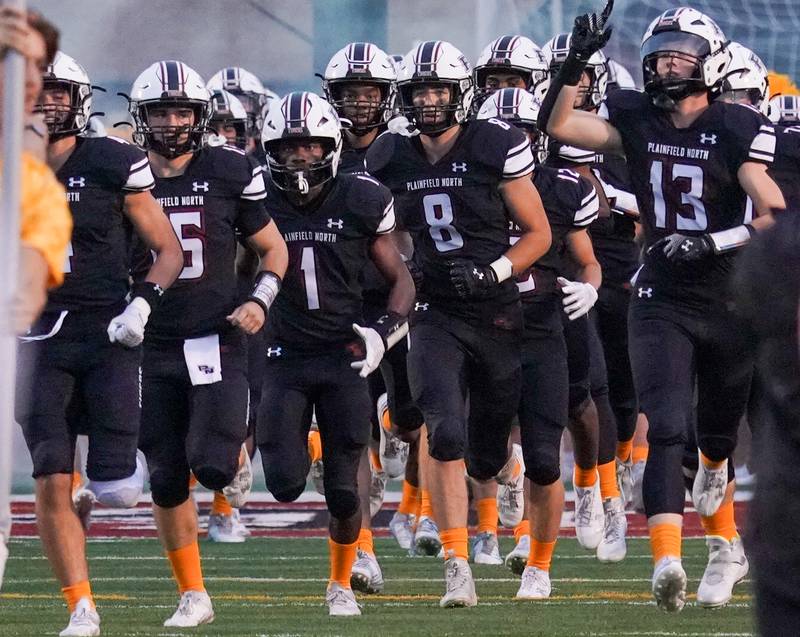 Plainfield North players take the field for warmups prior to kick-off against Oswego at Plainfield North High School on Friday, Sept. 22, 2023.