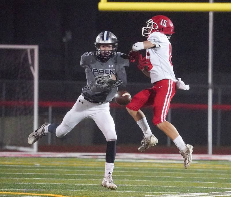 Oswego East's Andrew Pohlman (20) breaks up a pass intended for Yorkville's Dillon Jaskowski (15) during a football game at Yorkville High School on Friday, Oct. 13, 2023.