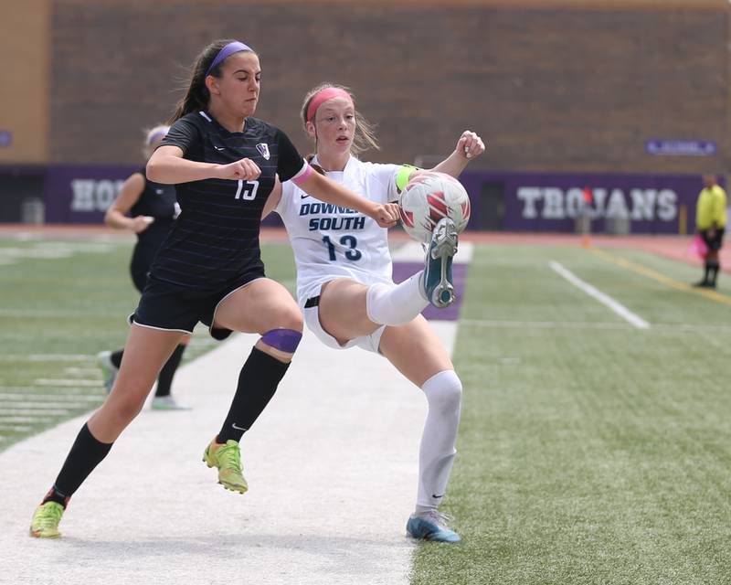 Downers Grove South's Emily Petring (13) kicks the ball while being defended by Downers Grove North's Katelyn HennellyC (15) during soccer match between Downers Grove North at Downers Grove South.  May 6, 2023.