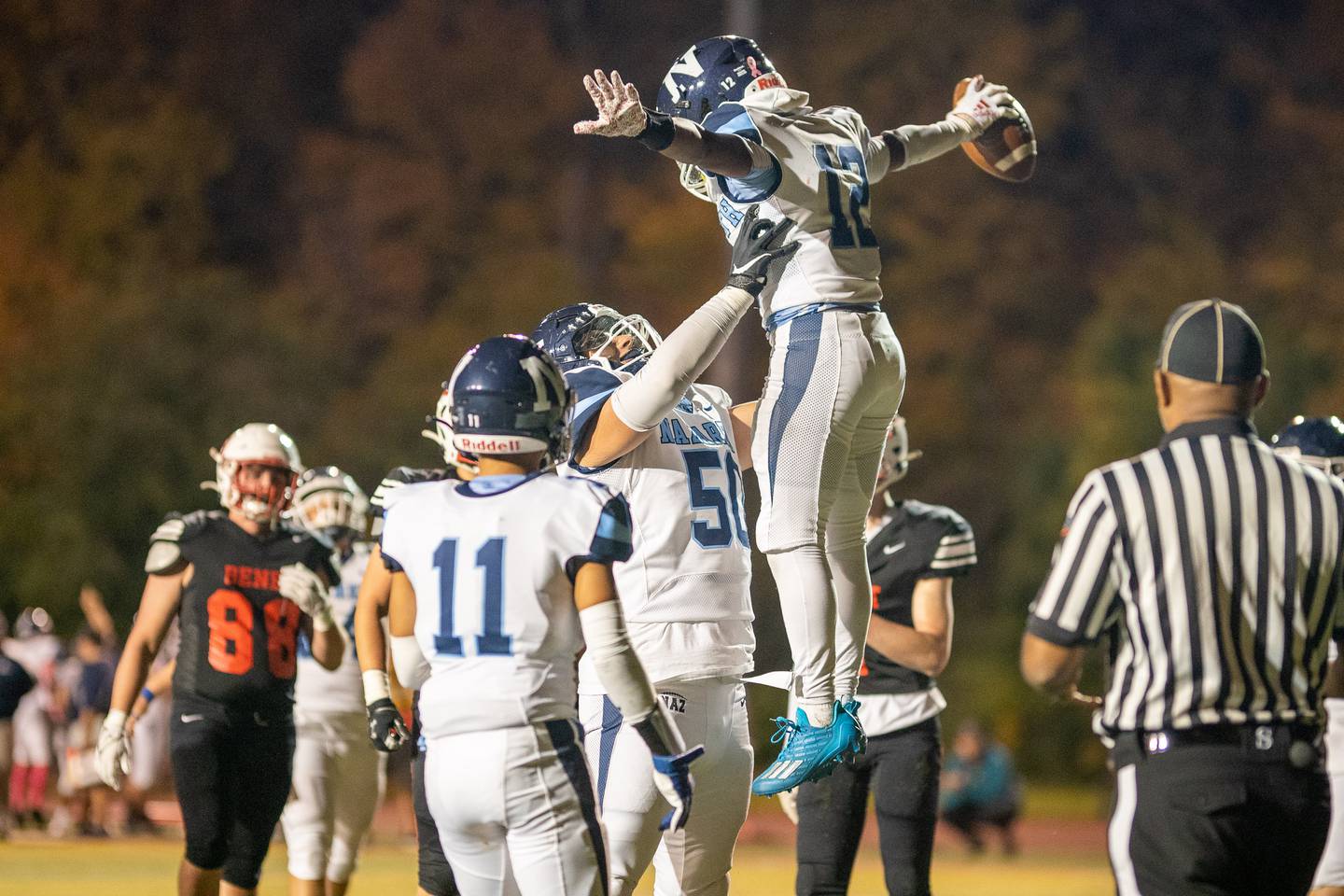Nazareth Academy's Edward Mcclain Jr (12) is lifted up by William Beargie (50) after scoring a touchdown against Benet Academy during a football game at Benedictine University in Lisle on Friday, Oct 21, 2022.