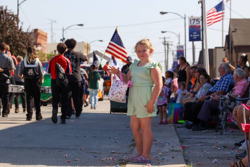 A young paradegoer waves to participants in the Grand Pumpkin Parade during the St. Anne Pumpkin Festival on Saturday, Oct. 4, 2025.