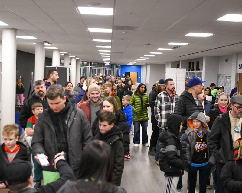 A line of people reached out the doors for a sold-out crowd for the Harlem Wizard vs Downers Grove Staff on Sunday Jan. 19, 2025, held at Downers Grove South High School.