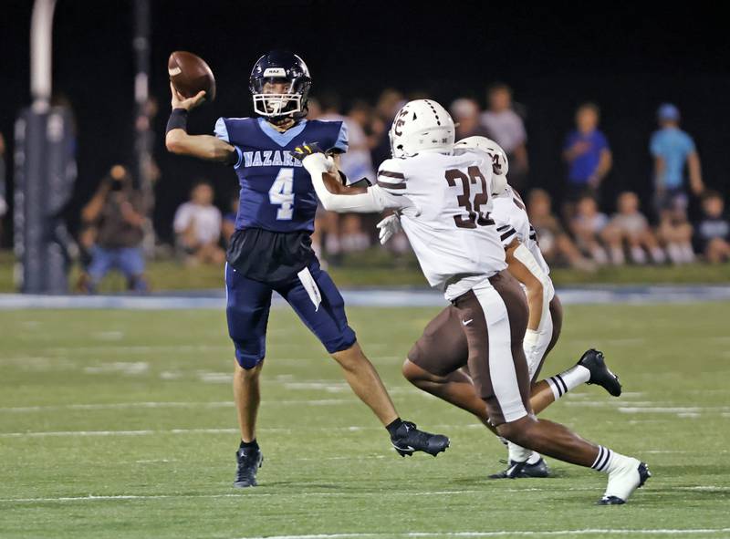 Nazareth's Frankie Nichols (4) throws under pressure during the varsity football game between Mt. Carmel high school and Nazareth Academy on Friday, Sept. 12, 2025 in La Grange Park, IL.