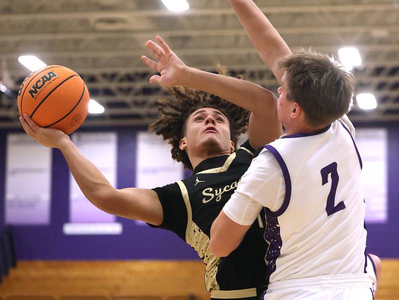 Sycamore's Josiah Mitchell goes to the basket against Rochelle's Van Gerber Friday, Dec. 5, 2025, during their game at Rochelle High School.