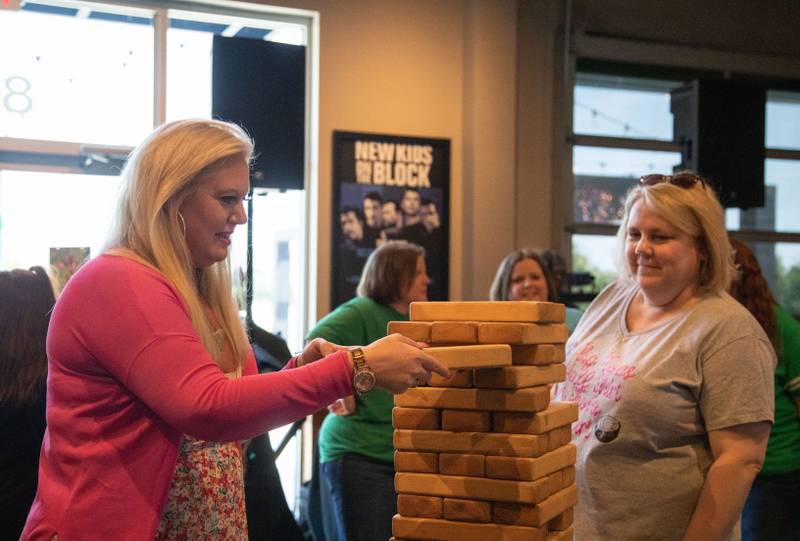 Nicole Weston, left, and Karen Olfon play a giant block game during the third anniversary of Wahlburgers in St. Charles on July 29, 2023.