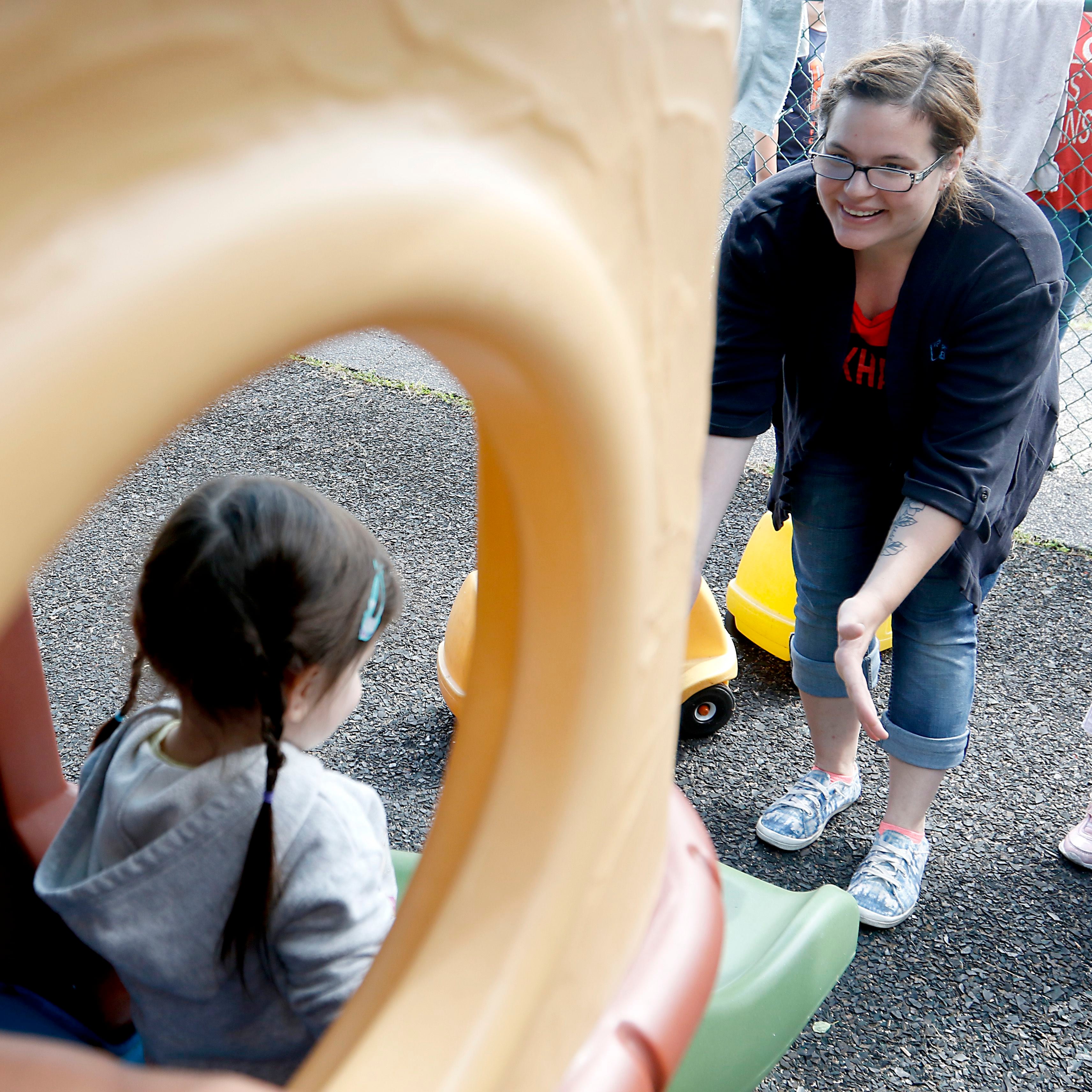Teacher Ashleigh Bergstrand interacts with a with a student as she plays on the playground Thursday, July 28, 2022, at the Friendship House, 100 South Main Street, in Crystal Lake. Childcare centers are struggling to find enough teachers to maintain operations.
