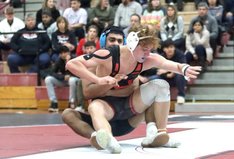 Huntley’s Alesia Pezzella (front) battles McHenry’s Ruben Melgarejo at 152 pounds in their Fox Valley Conference dual on Friday in Huntley.