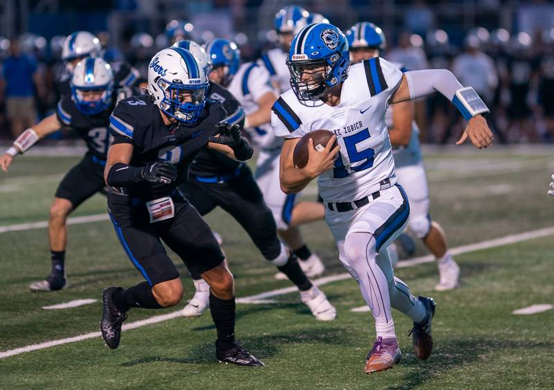 Lake Zurich's Ashton Gondeck (15) carries the ball on a keeper against St. Charles North's Nathan Carpenter (3) during a football game at St. Charles North High School on Friday, Sep 2, 2022.