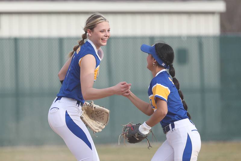 Joliet Central’s Hayden Voss, left, celebrates an out with Natalie Reyes against Wilmington on Tuesday, March 12 in Joliet.