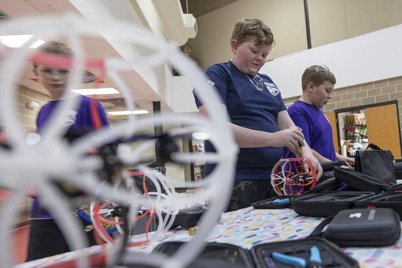 Jake Lohse (left) and Cade Kirchhoff, both 12, work on after competition maintenance of their drones Wednesday, Jan. 25, 2024.