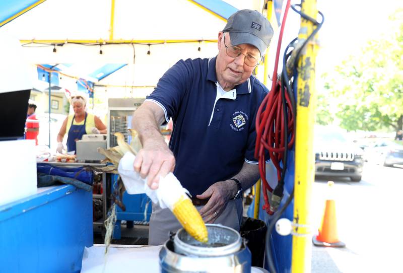 Larry Saladin dips corn in melted butter at the Knights of Columbus food booth during opening day of Swedish Days Festival in Geneva on Wednesday, June 22, 2022. The festival runs through Sunday, June 26, 2022.