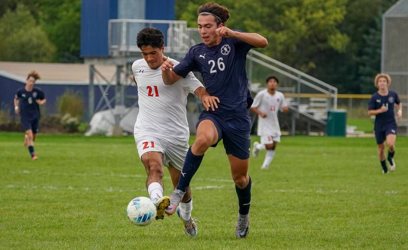 Oswego’s Christian Cid (21) challenges Oswego East's Josh Lopez (26) for the ball during a soccer match at Oswego East High School on Tuesday, Sept. 26, 2023.