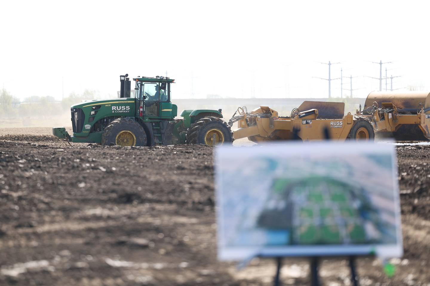 An arial rendering of the 100 acre New Lenox Crossroads Sports Complete sits in the foreground as work is underway at the sports complex site on Monday, April 22, 2024 in New Lenox.