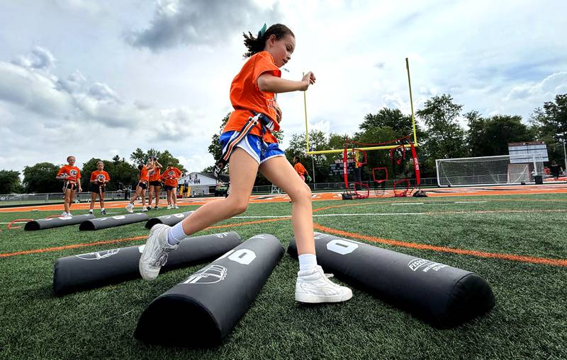 Liyah Zagone runs through a drill during the Chicago Bears Mini Monsters Flag Football Camp on Wednesday, July 16, 2025. at McCracken Field in McHenry.