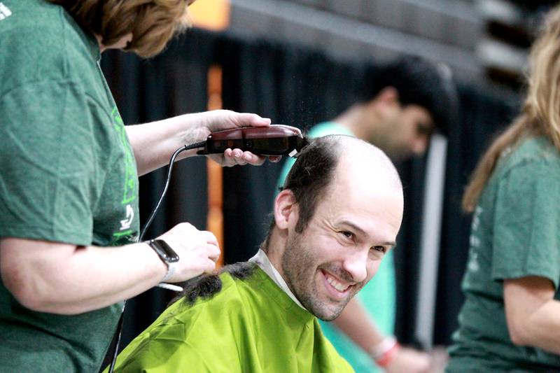 St. Charles East Head Baseball Coach Derek Sutor has his head shaved by Andrea Bauer of St. Charles during the St. Charles Challenge fundraiser for the St. Baldrick’s Foundation on Friday, March 15, 2024 at St. Charles East High School.