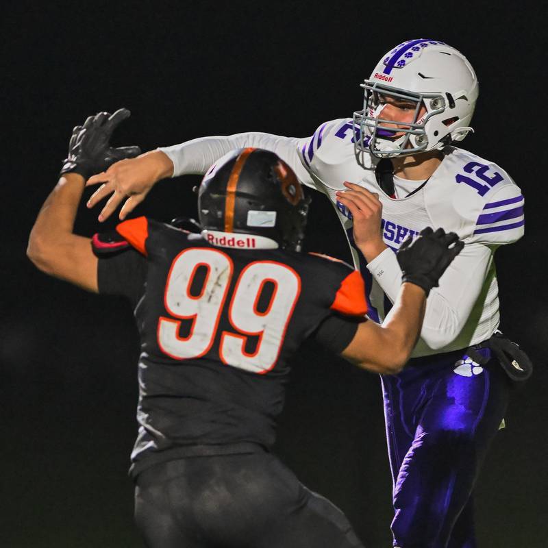 Hampshire quarterback Luke Lacke gets off a pass against Crystal Lake Central linebacker Anthony Morales during their Fox Valley Conference game on Friday, Oct. 20, 2023 in Crystal Lake.