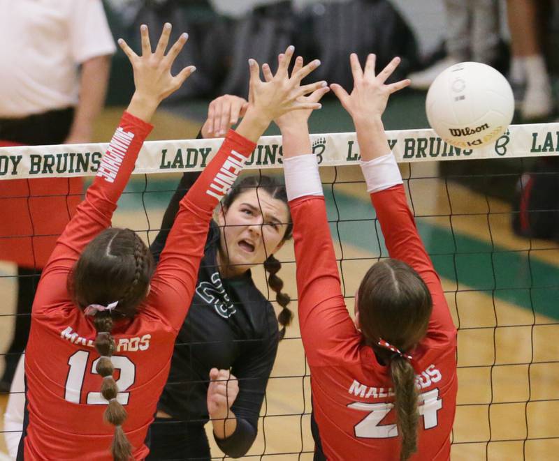 St. Bede's Ali Bosnich (23) sends a kill past Henry's Kaitlyn Anderson (12) and teammate Harper Schrock (24) in the Class 1A semifinal game on Wednesday, Oct. 16, 2022 at St. Bede Academy in Peru.