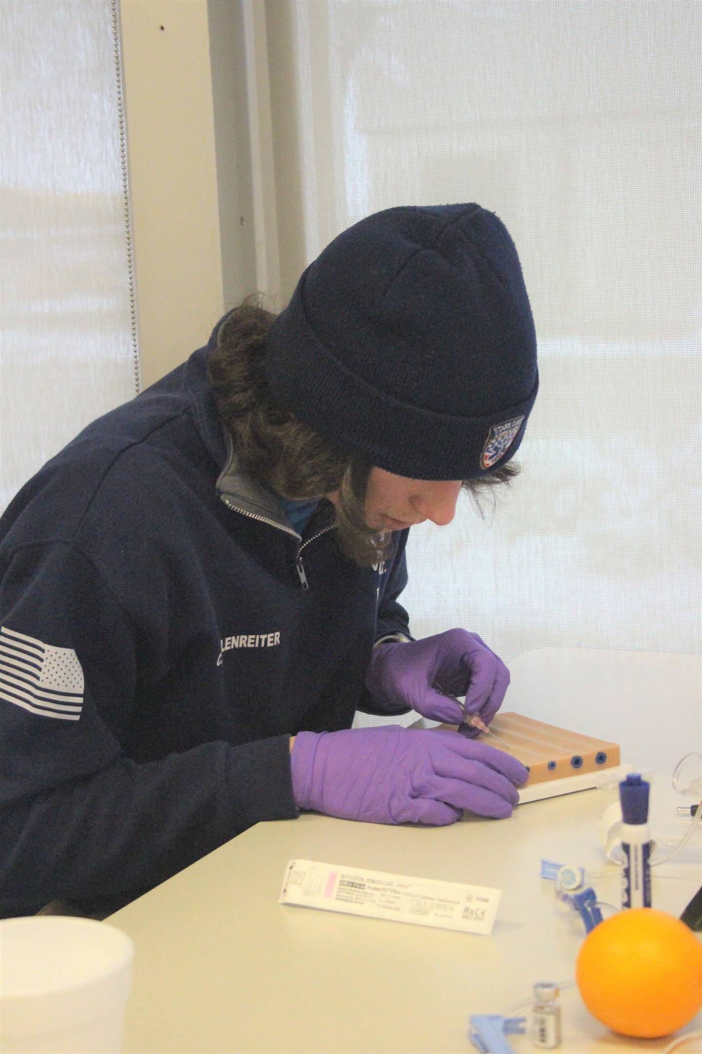 Illinois Valley Community College EMS student Tyler Walsh starts an IV on a training arm.