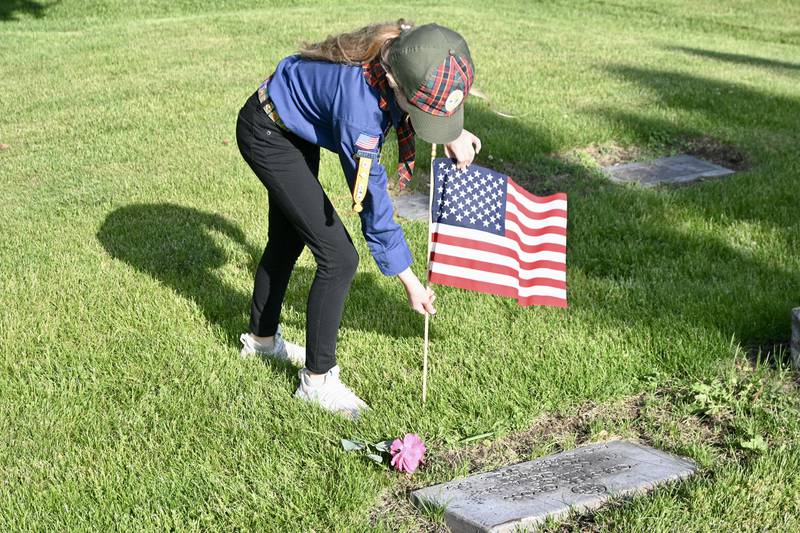 Avalean Arnold, of Peru Cub Scouts' Pack 3709, places a flag on a veteran's grave on Thursday, May 22, 2025, at Peru City Cemetery.